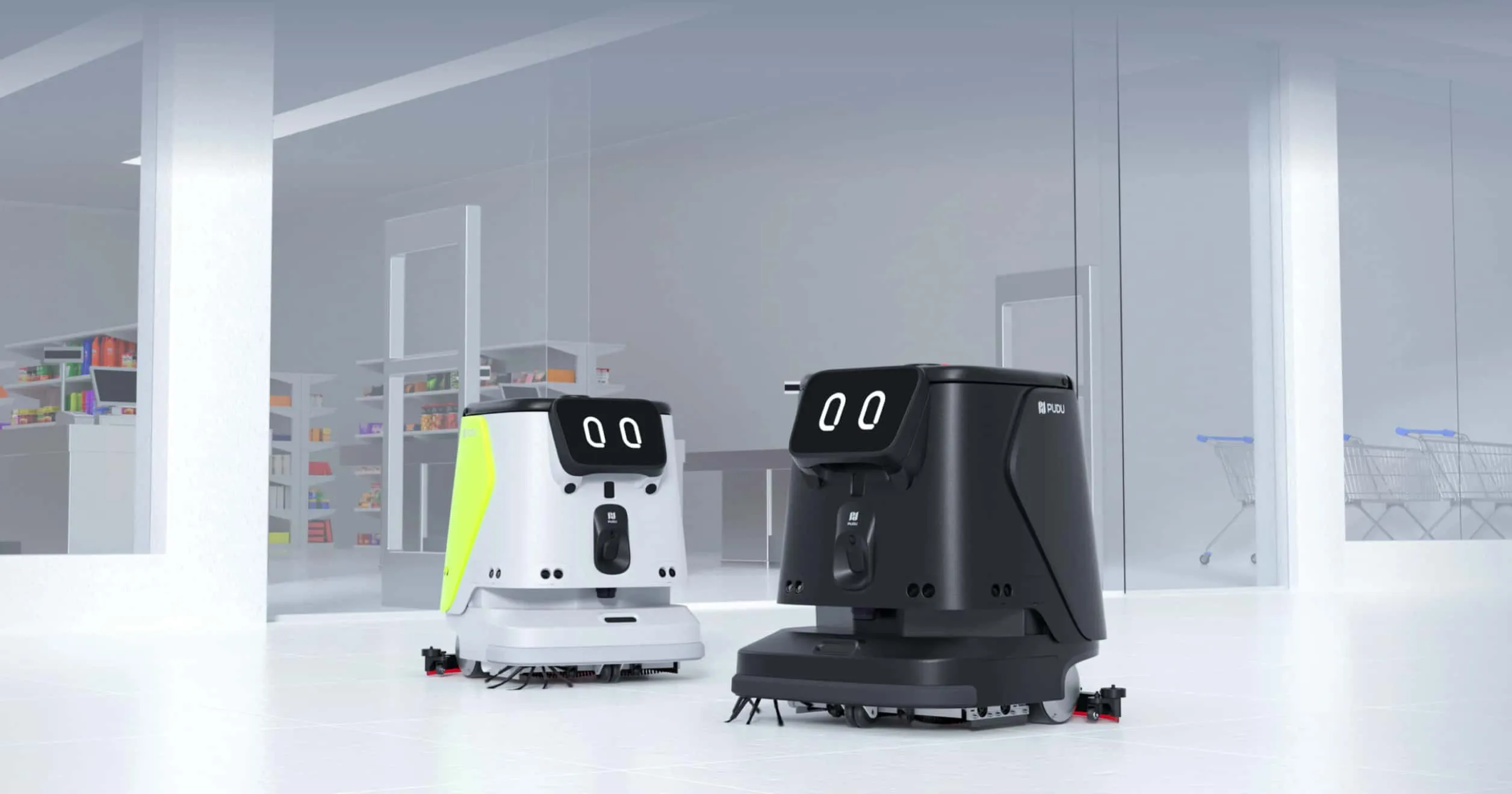 Mağaza girişinde yan yana iki PUDU CC1 Pro temizlik robotu