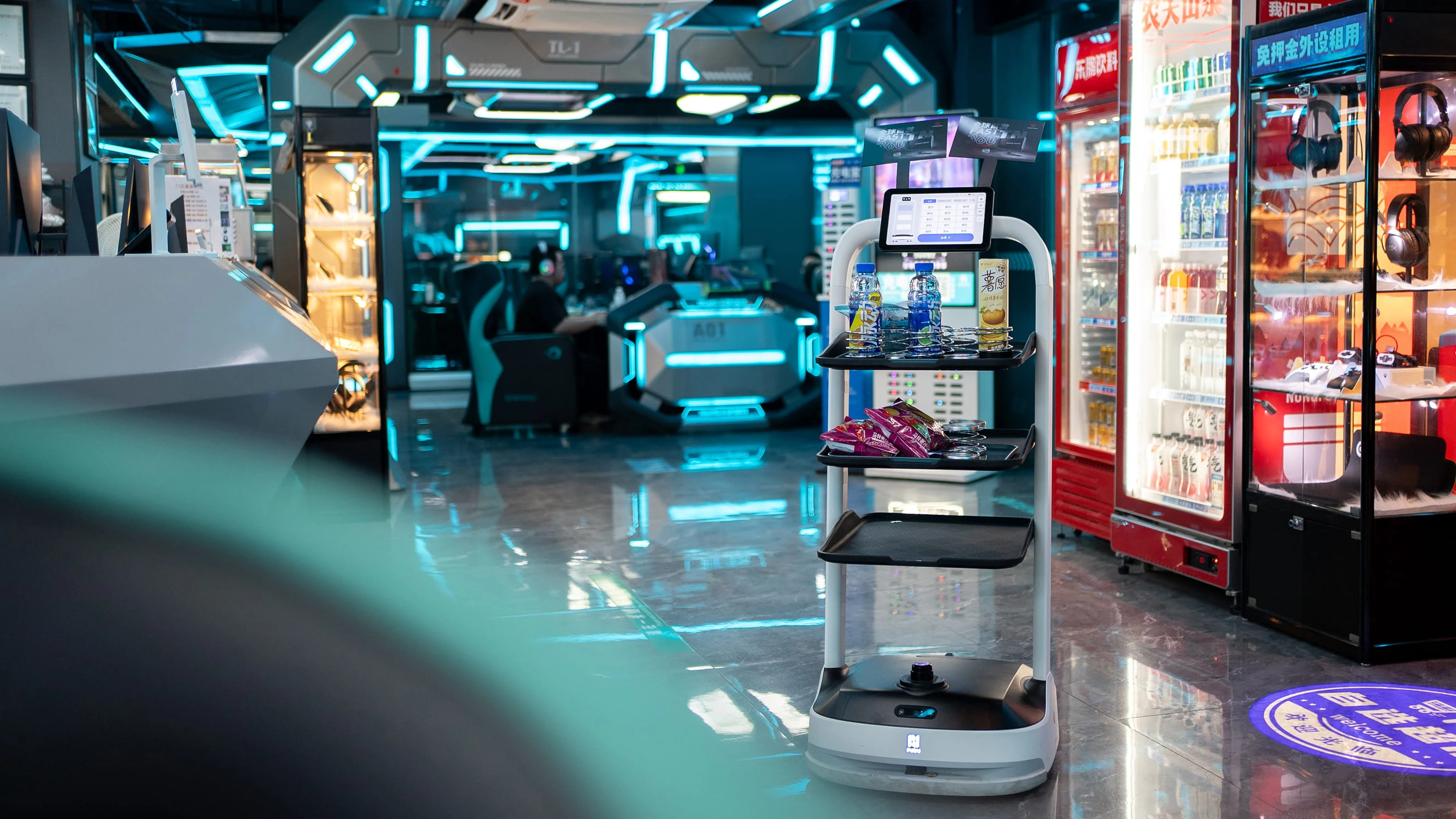 Oyun salonunda ürün raflı, ekranlı servis robotu