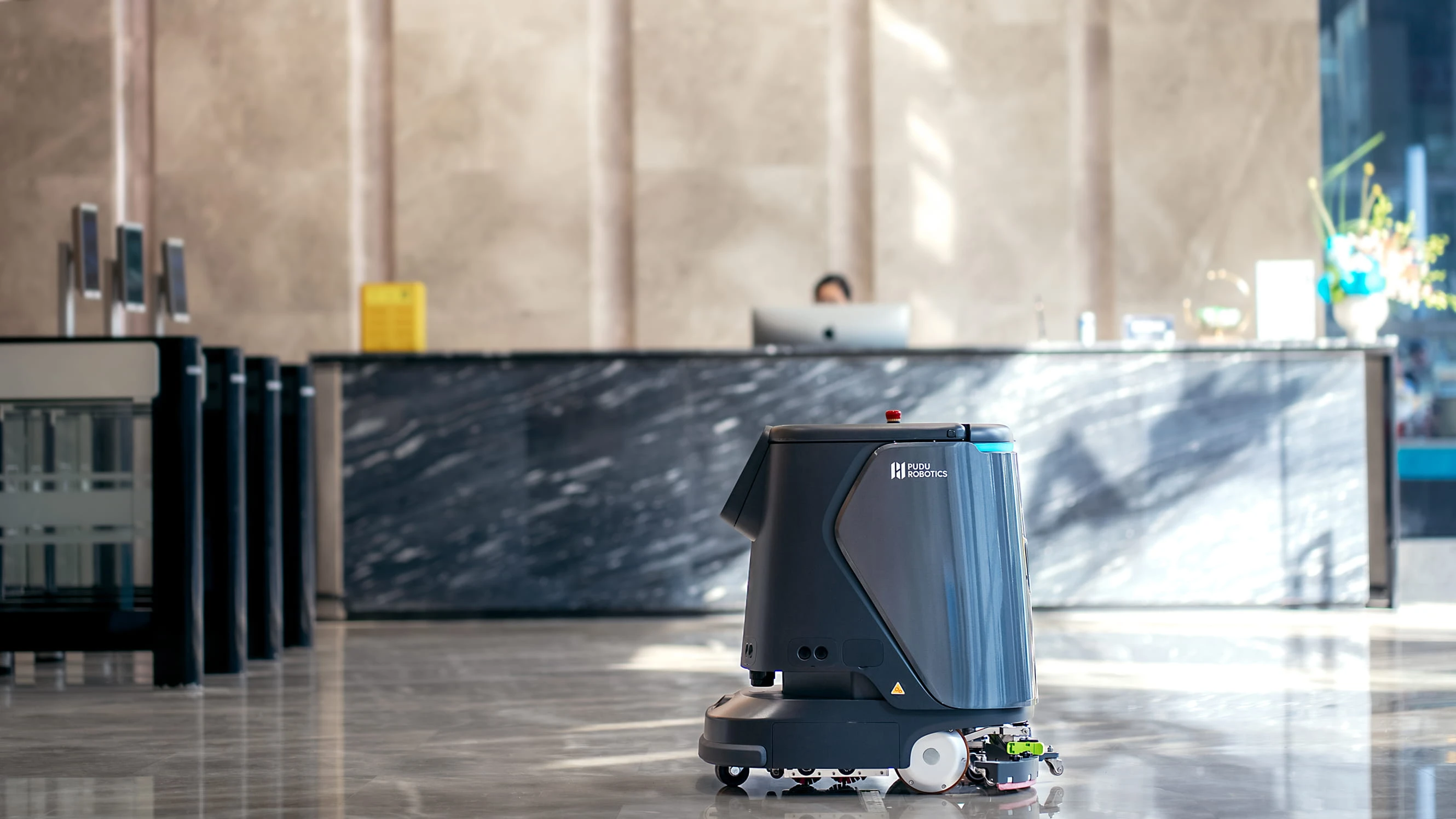 Ofis binası lobisinde resepsiyon önünde çalışan ticari temizlik robotu